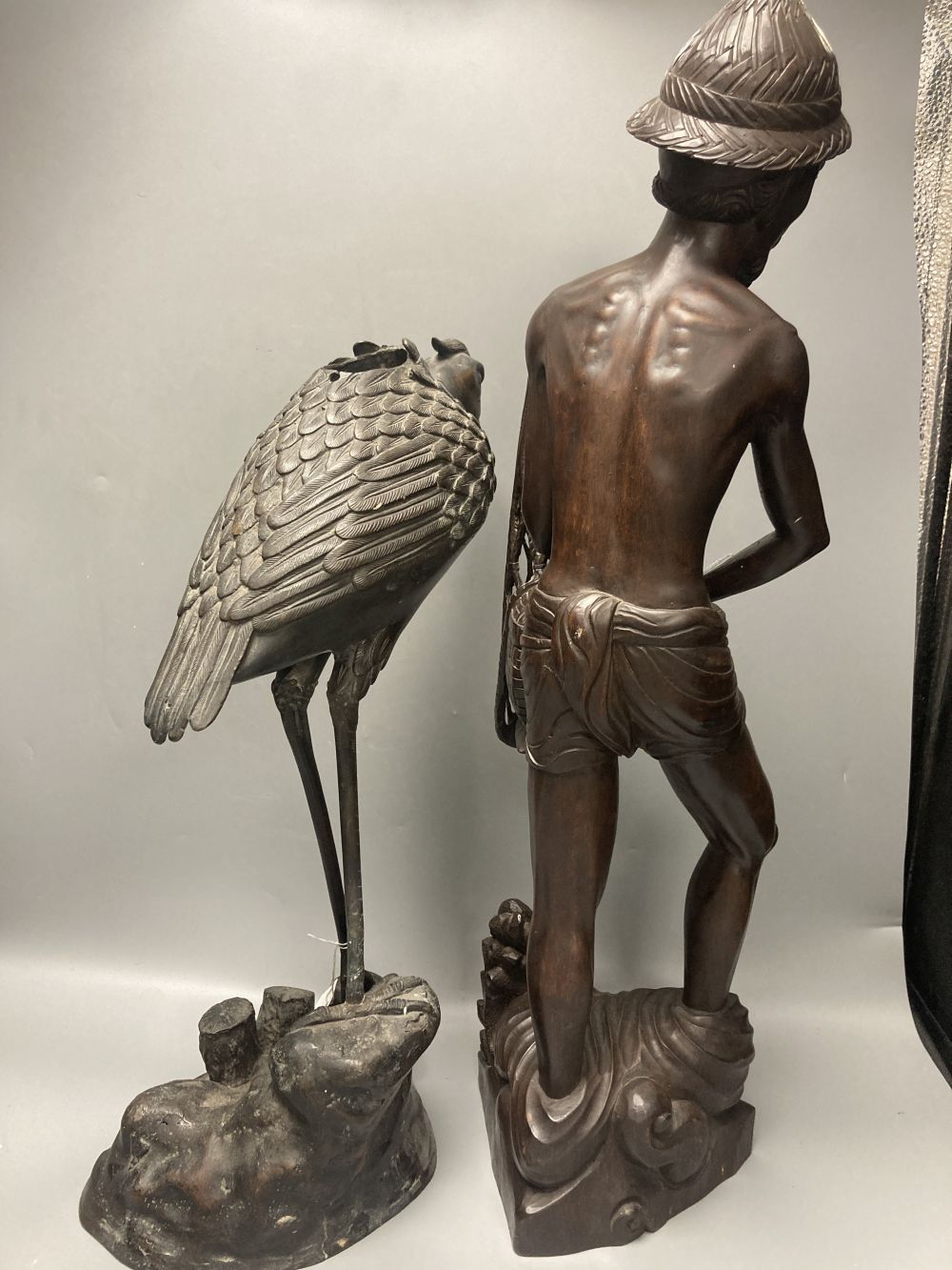 A large Japanese bronze bird koro, 48cm and a large Indonesian hardwood figure of a fisherman, 60.5cm